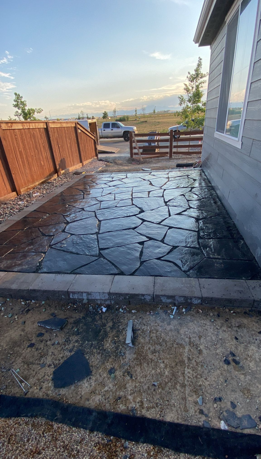Flagstone patio with paver border installed beside a Northern Colorado home